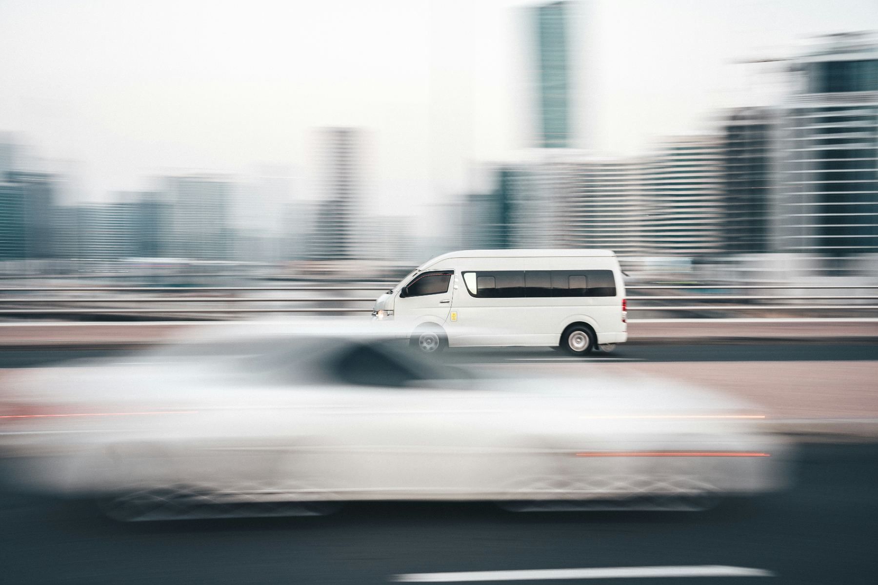 A white delivery van driving through the city